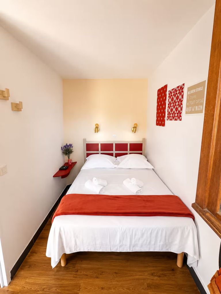 Chambre de Blue View Cannes avec lit double 140 x 190 cm, tête de lit rouge et linge de maison fourni