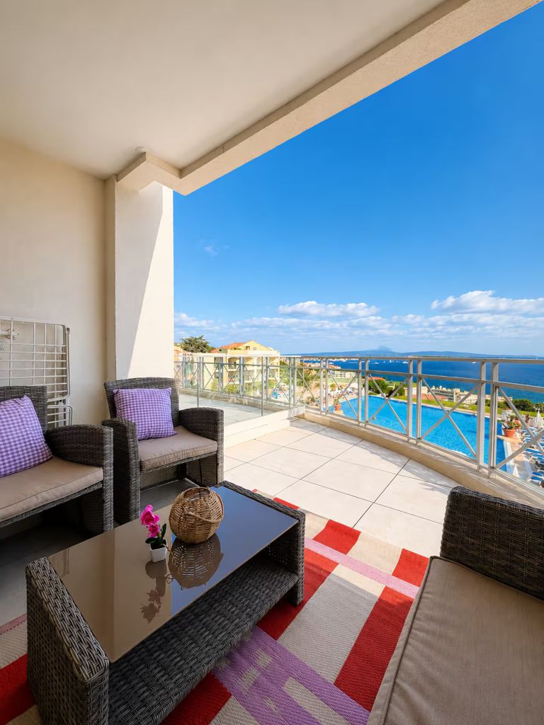 Salon d'extérieur sur le balcon de Blue View Cannes avec vue sur la piscine et la mer